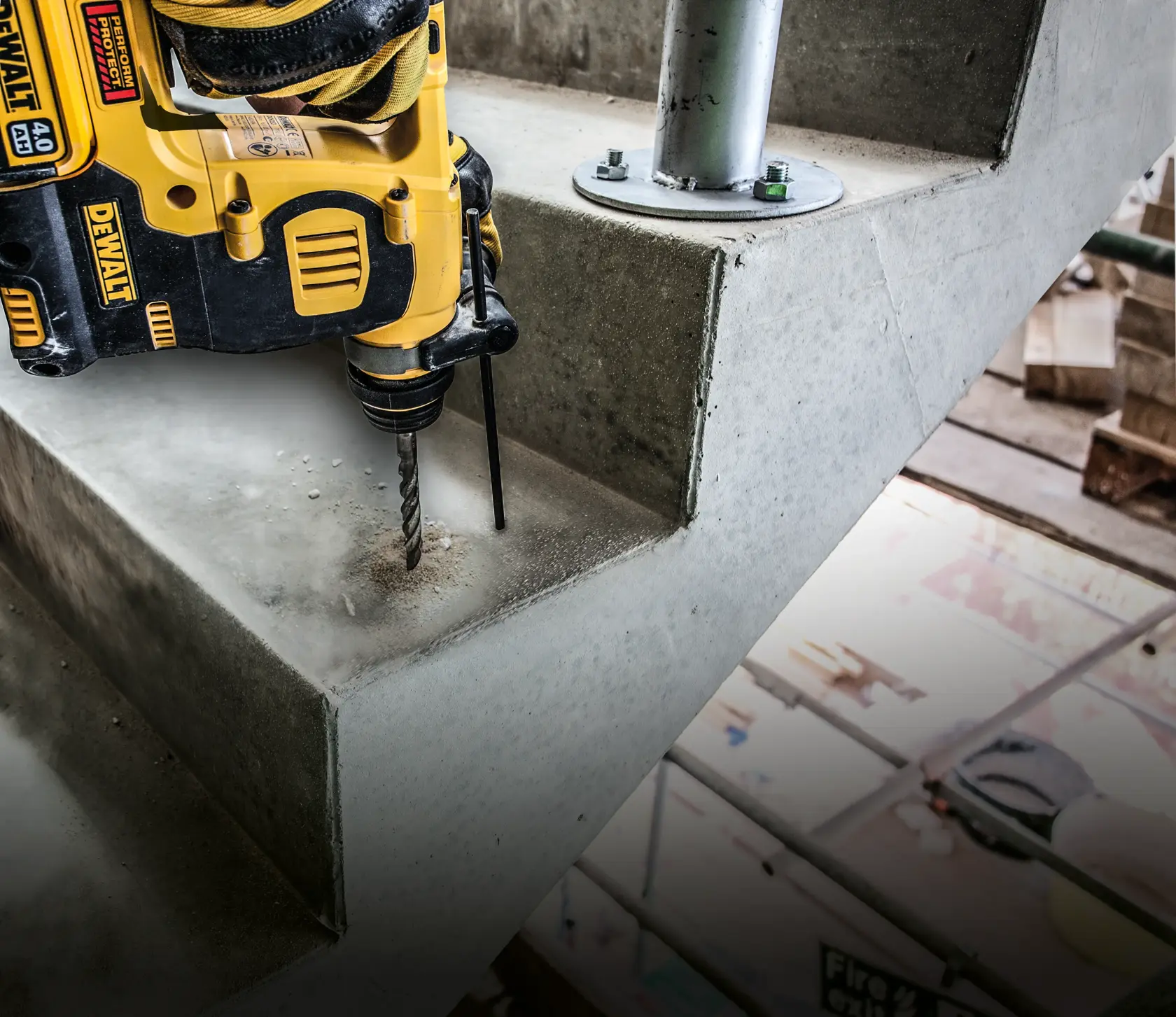 DEWALT drill in use, drilling into a concrete staircase step at a construction site.